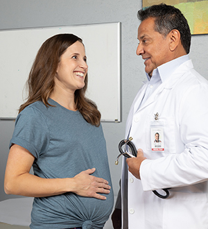 Woman talking to healthcare provider in exam room.